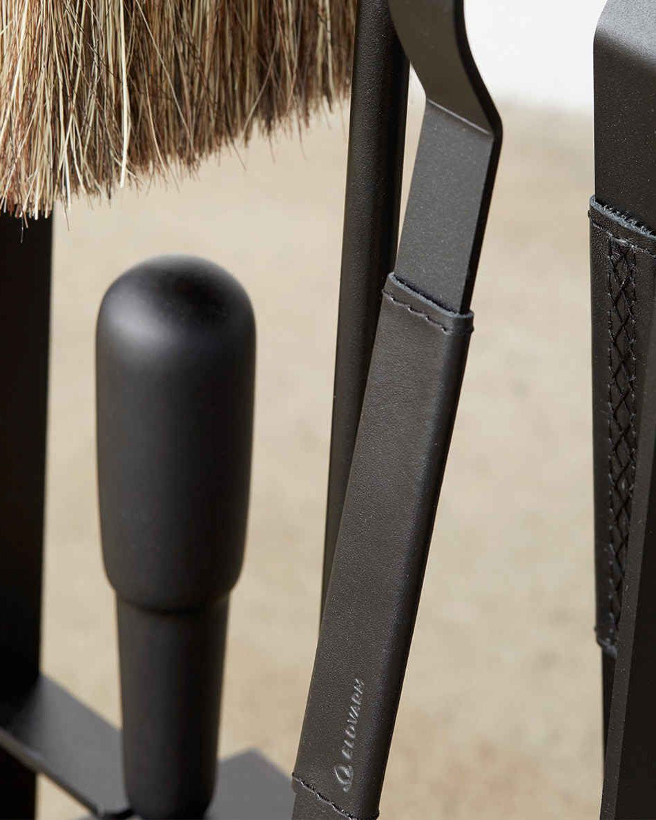 A close up of the leather details on the handle of the fireplace tongs. Shown from the front.