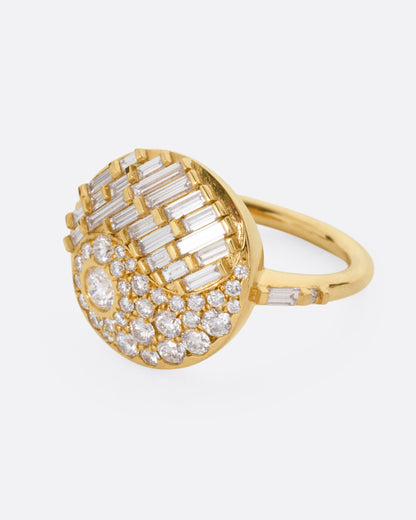 A yellow gold ring with a round face featuring a balance of brilliant round and baguette diamonds. Shown from the side.