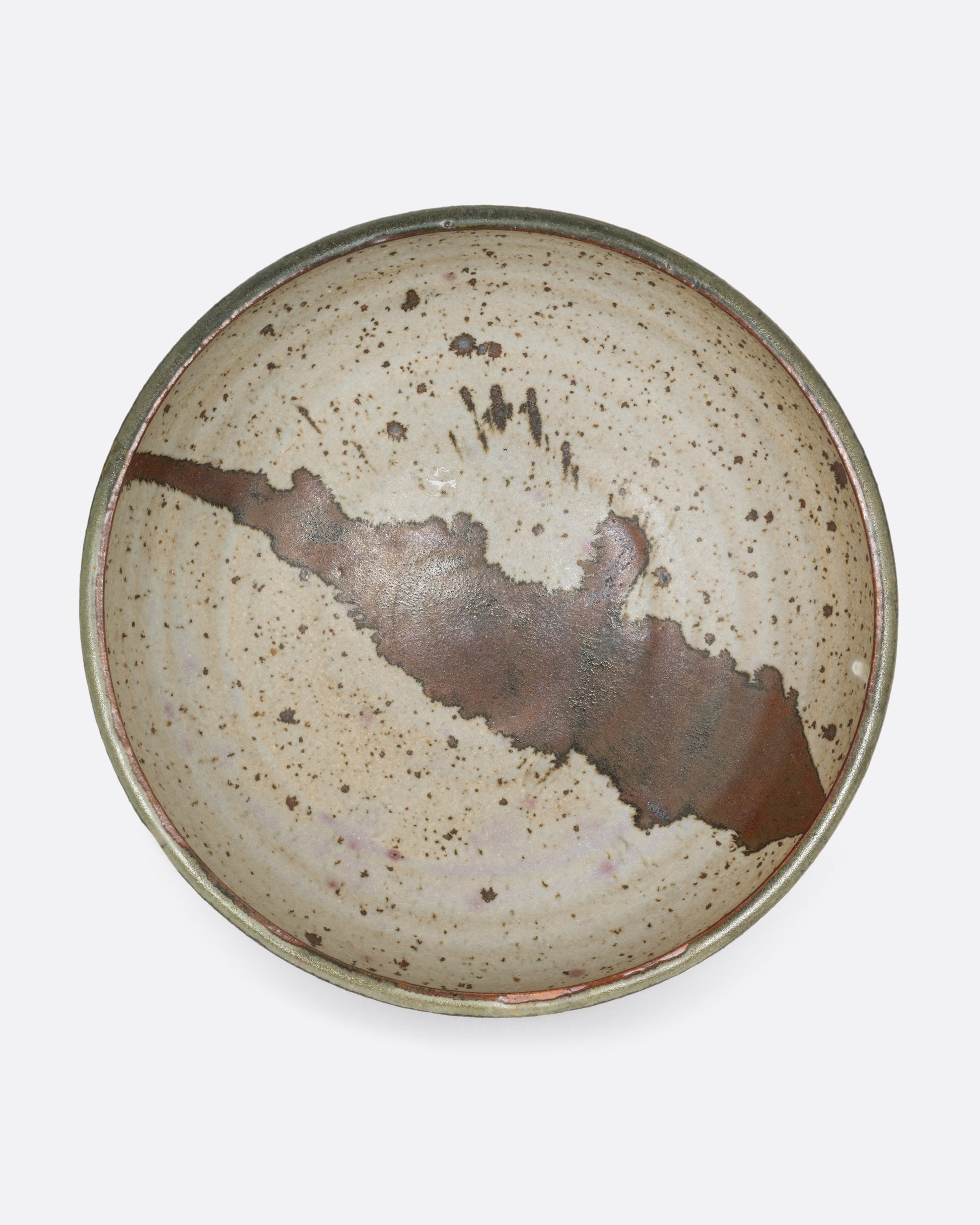 A ceramic serving bowl with a brown splattered glaze motif. Shown from the top.