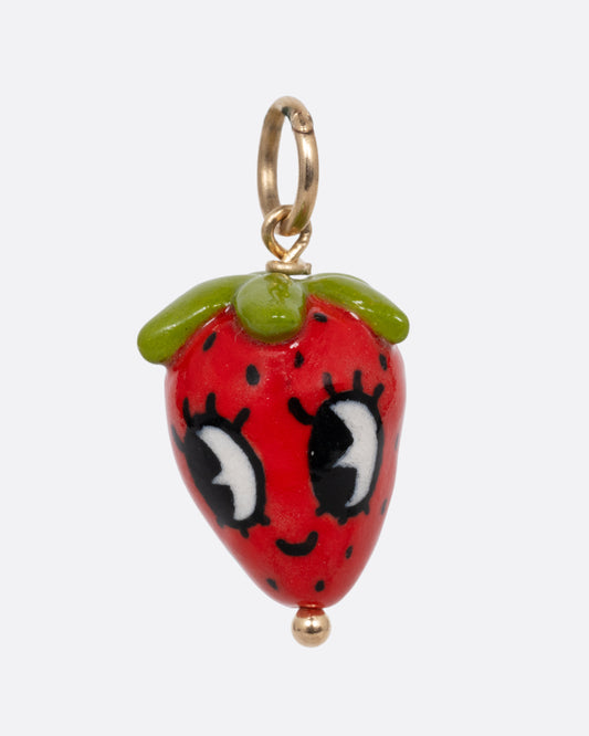 A red strawberry porcelain charm with a yellow gold bail. Shown from the front.