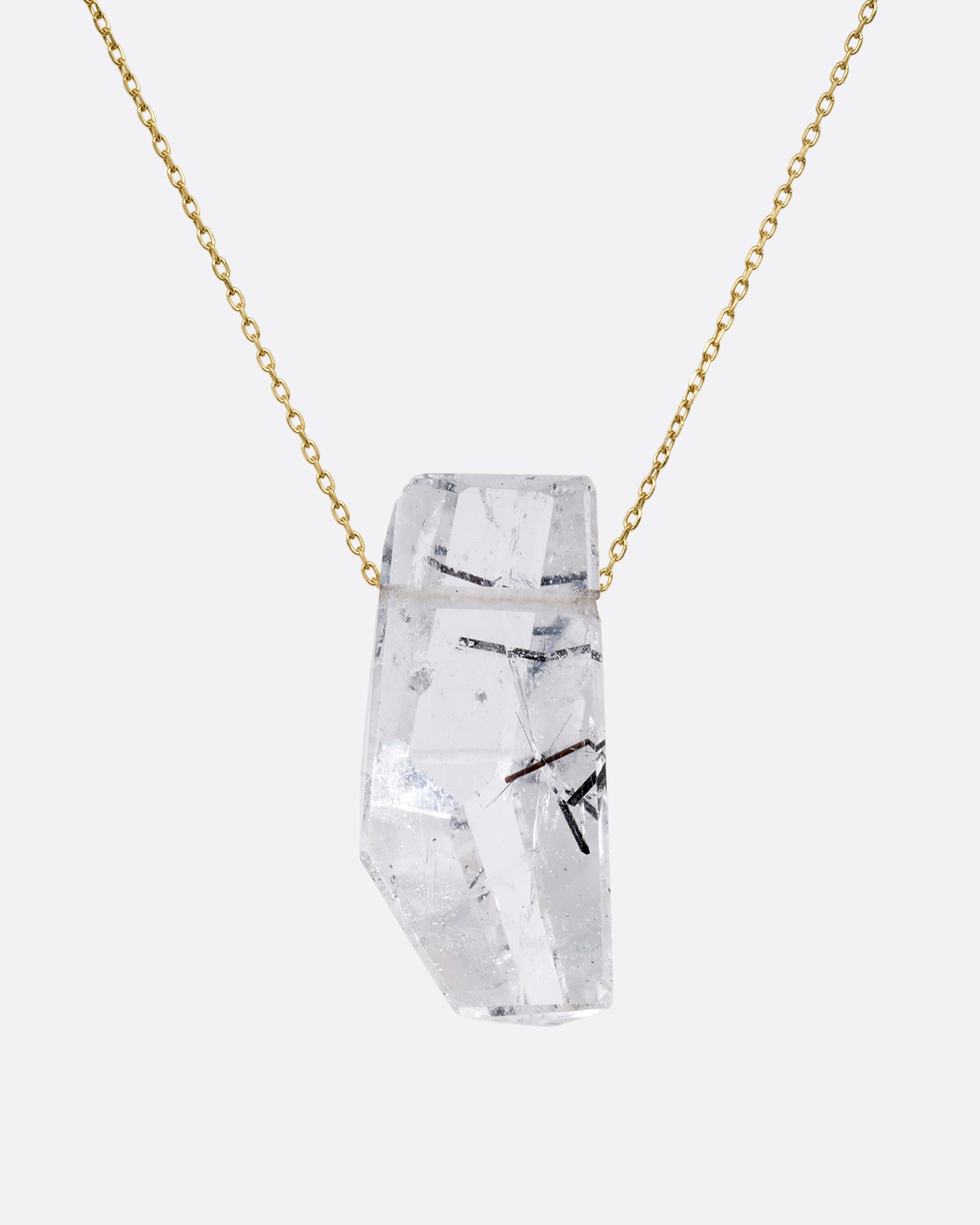 A drilled tourmalinated quartz on a fine yellow gold chain. Shown from the front.
