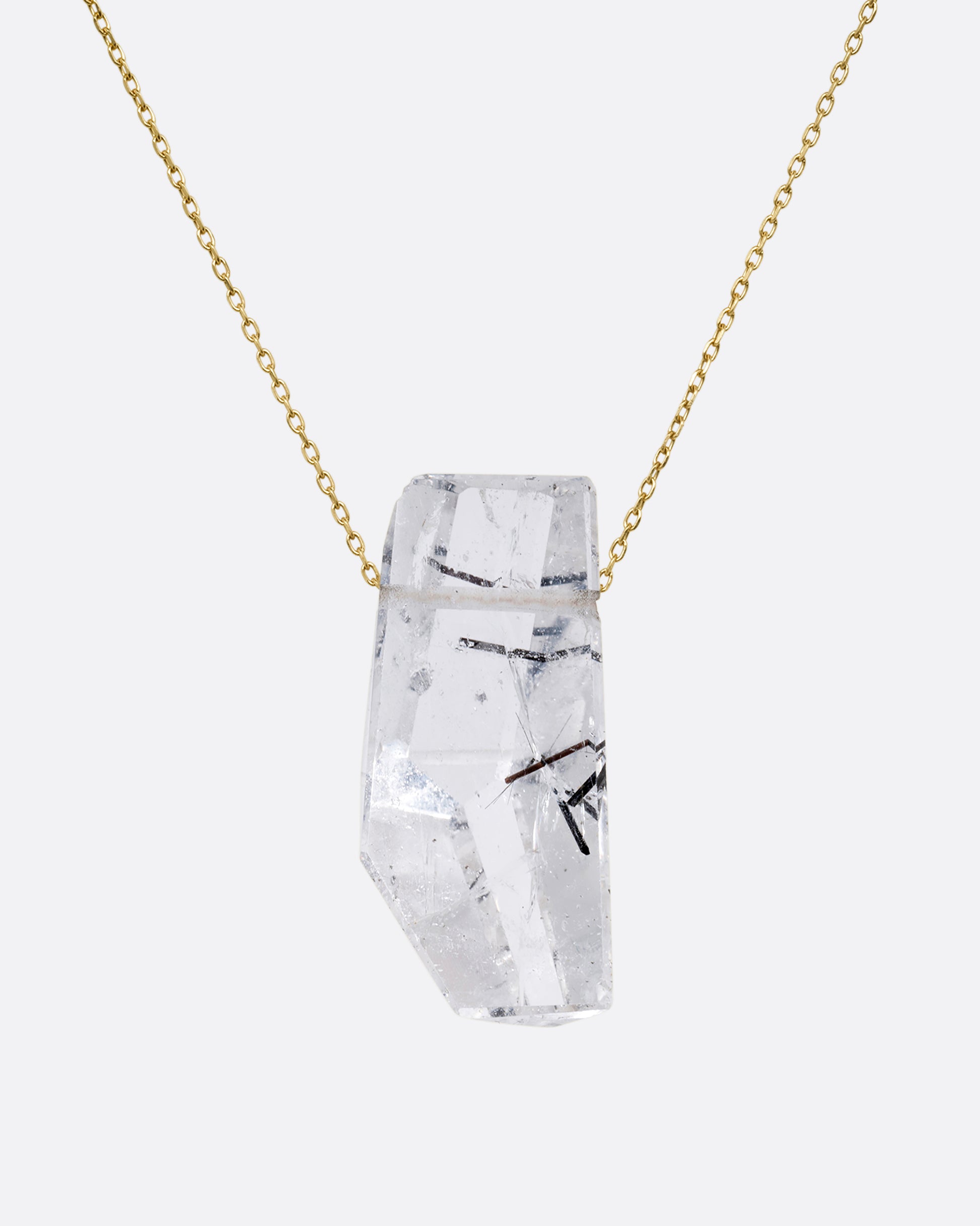 A drilled tourmalinated quartz on a fine yellow gold chain. Shown from the front.