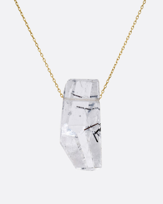 A drilled tourmalinated quartz on a fine yellow gold chain. Shown from the front.