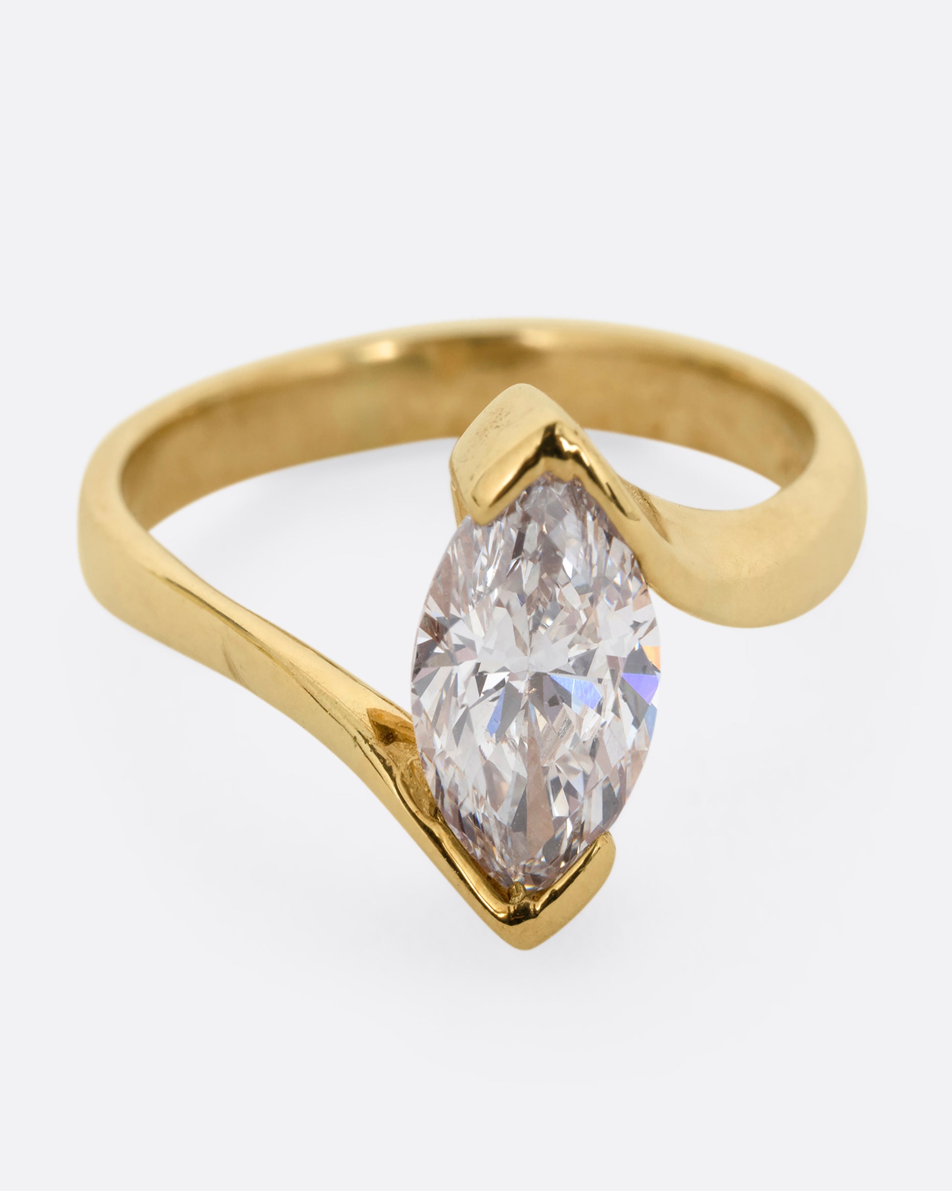 A yellow gold ring with a marquis diamond at the center. Shown from the front.