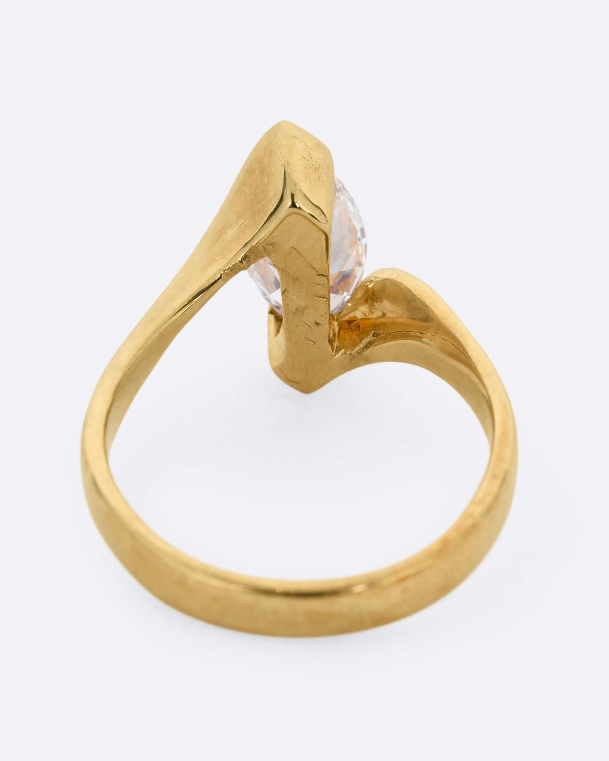A yellow gold ring with a marquis diamond at the center. Shown from the back.
