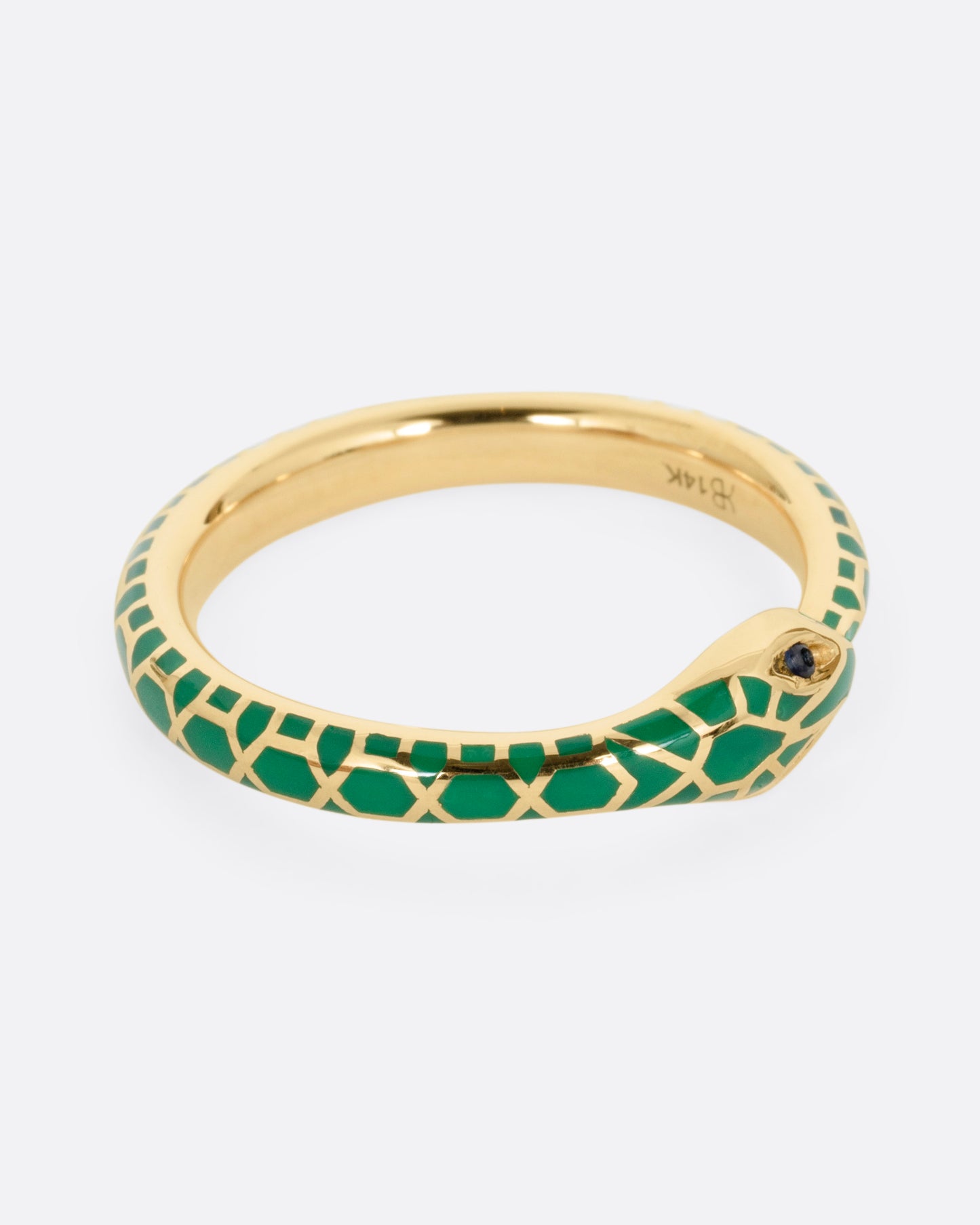 A yellow gold  ouroboros ring with sapphire eyes and a green enamel snake skin pattern, shown from the side.