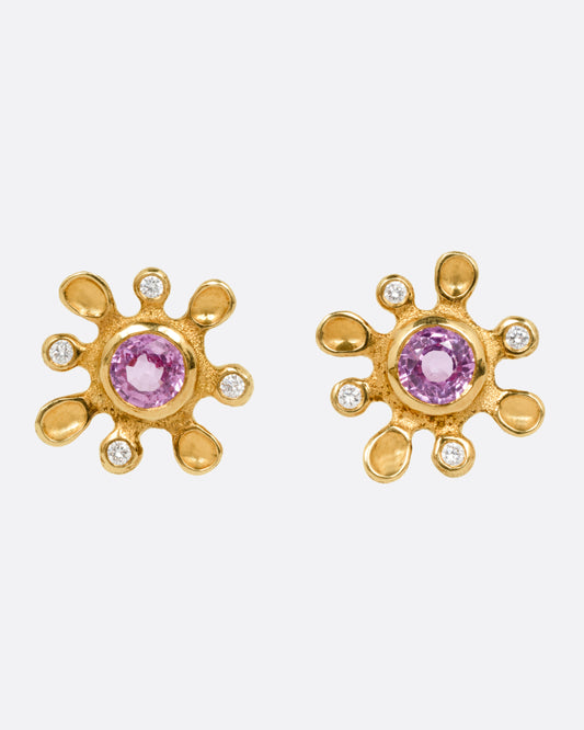 A pair of yellow gold diamond and sapphire flower stud earrings. Shown from the front.