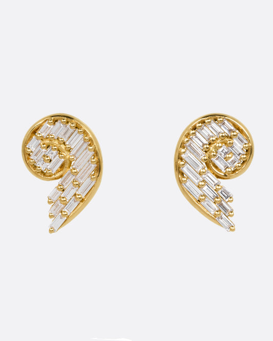 A pair of yellow gold curling earrings filled with baguette diamonds, shown from the front.