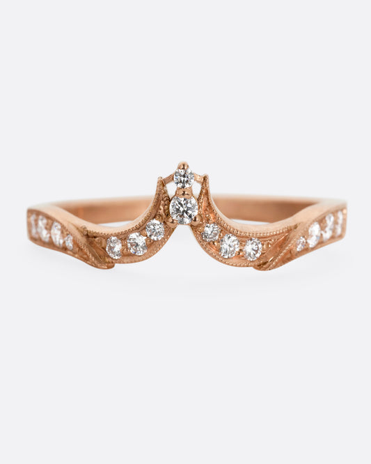 A rose gold ring with tapering curves of pavé diamonds that come to a point at the center. Shown from the front.