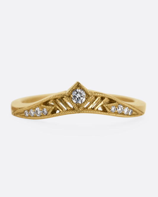 A subtly arched yellow gold ring with a diamond peak at the center flanked by graduated diamonds and cutouts. Shown from the front.