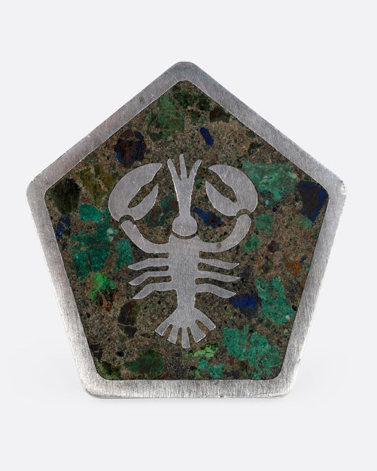 A silver pentagonal pin with a lobster set in malachite, turquoise, and lapis. Shown from the front.