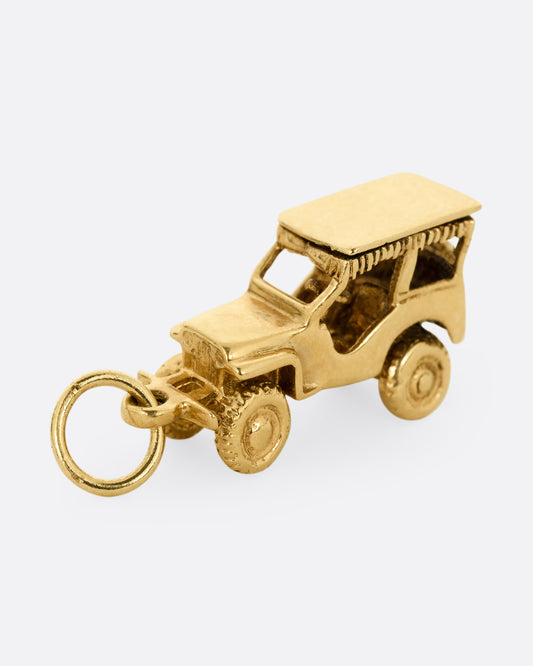 A yellow gold jeep charm. Shown standing up from the side.