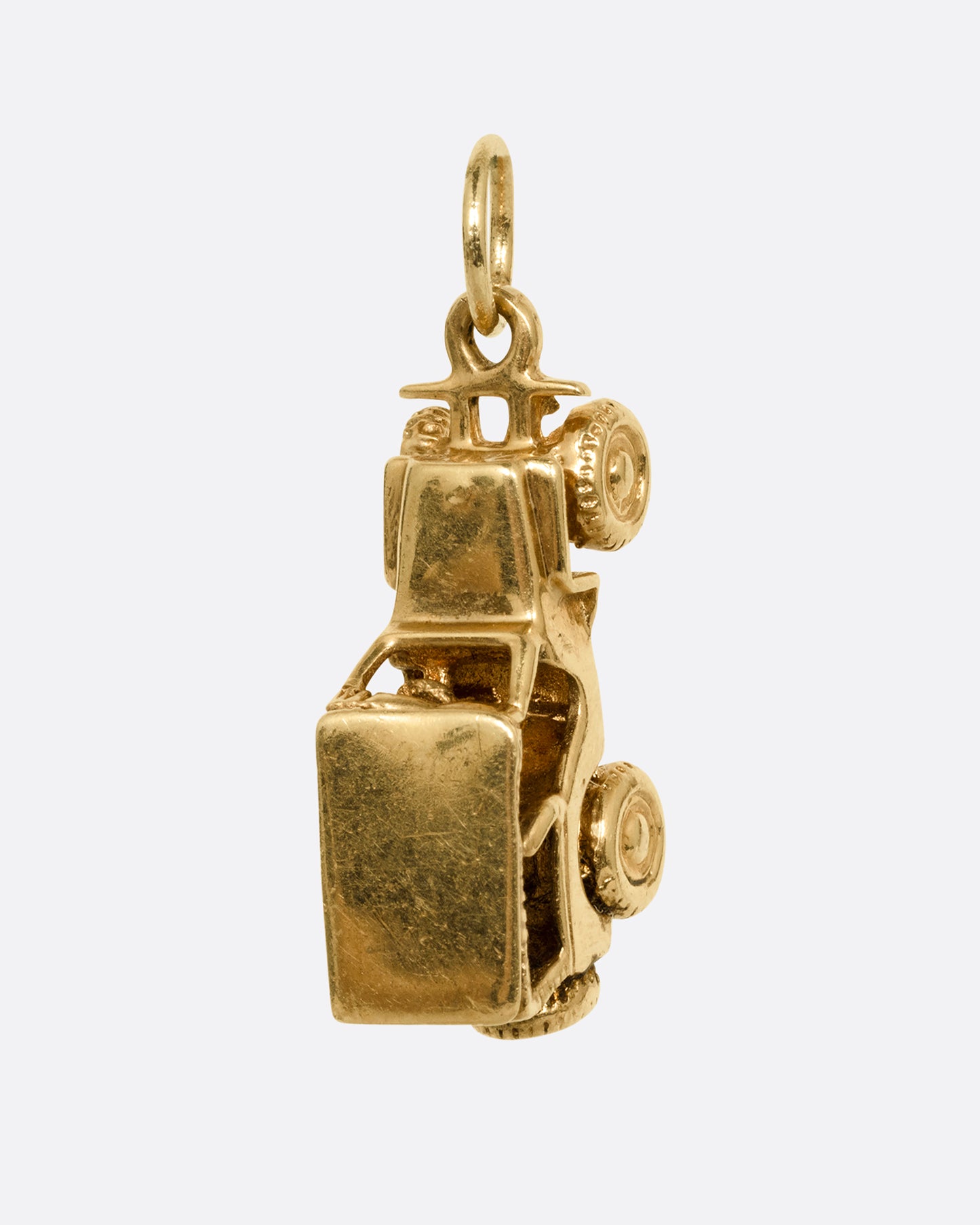 A yellow gold jeep charm. Shown standing up from the front.
