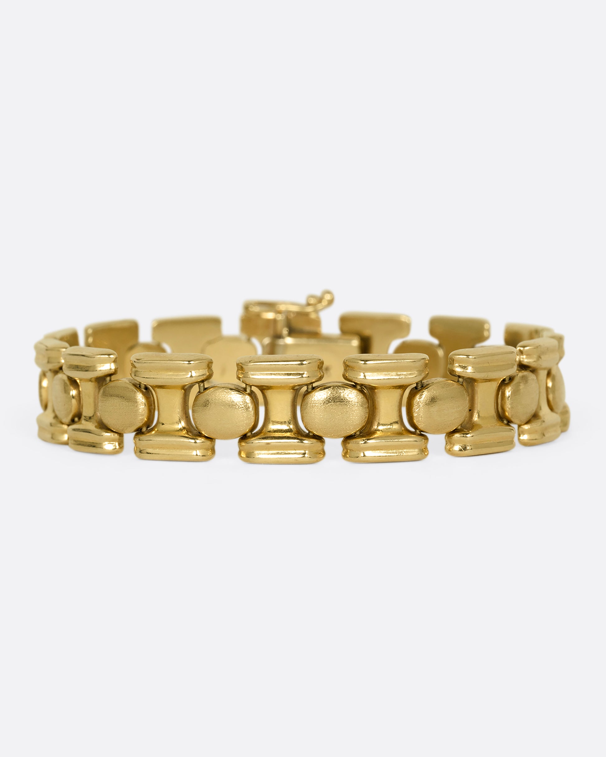 A yellow gold bracelet with repeating oval sections. Shown from the front.