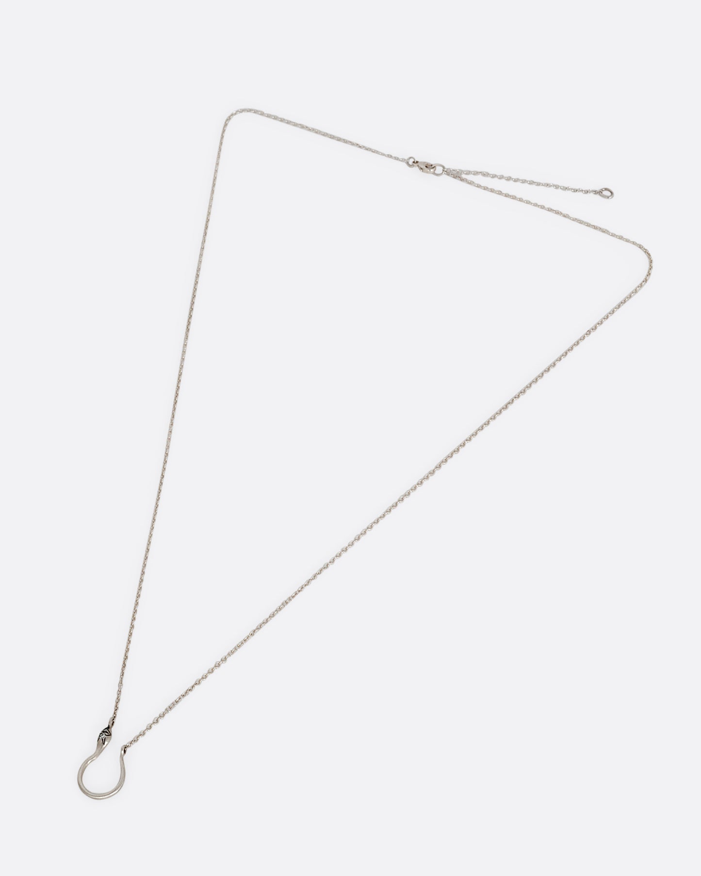 A silver snake shaped charm holder with diamonds on its face, hanging from a cable chain. Shown clasped lying flat.