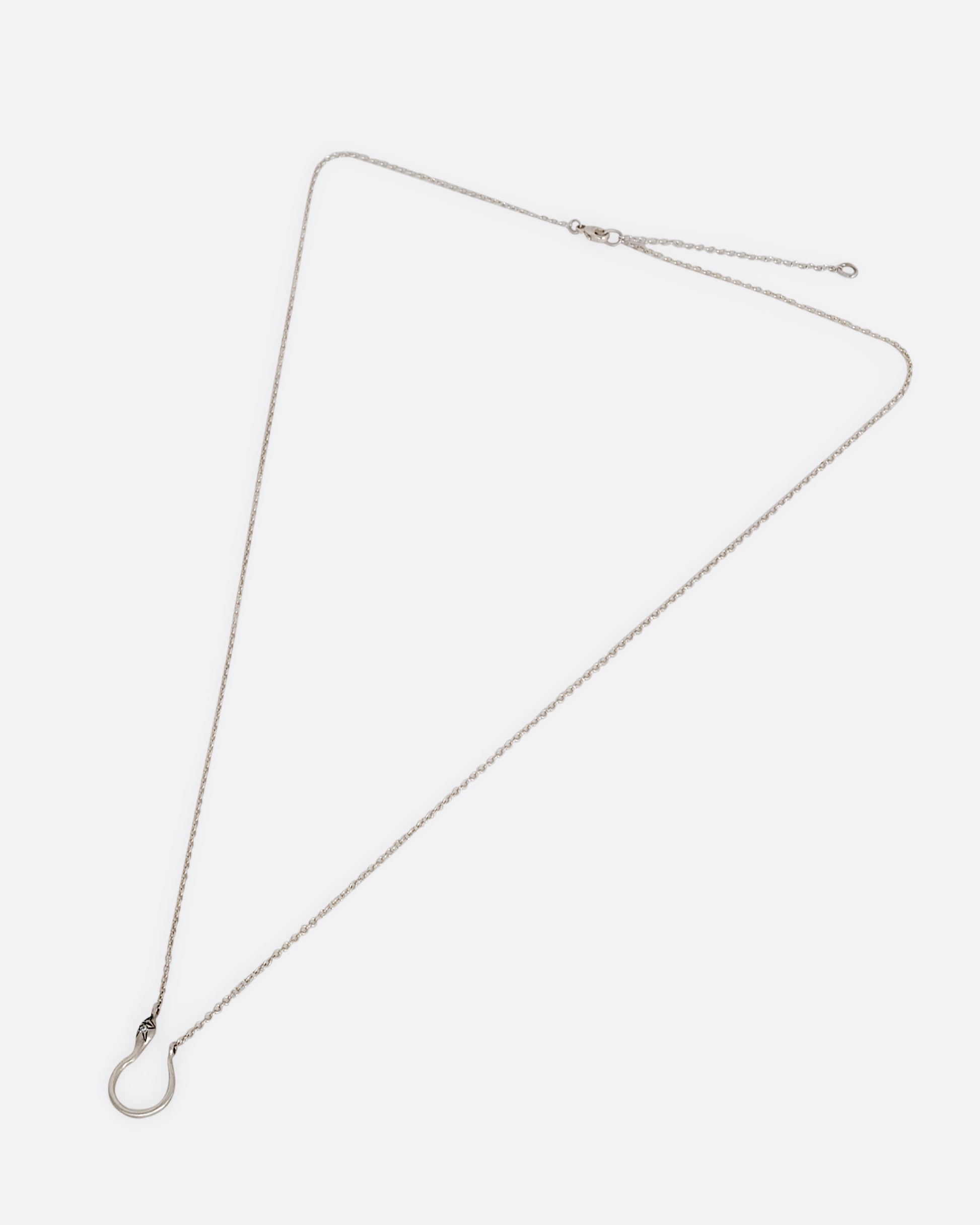A silver snake shaped charm holder with diamonds on its face, hanging from a cable chain. Shown clasped lying flat.