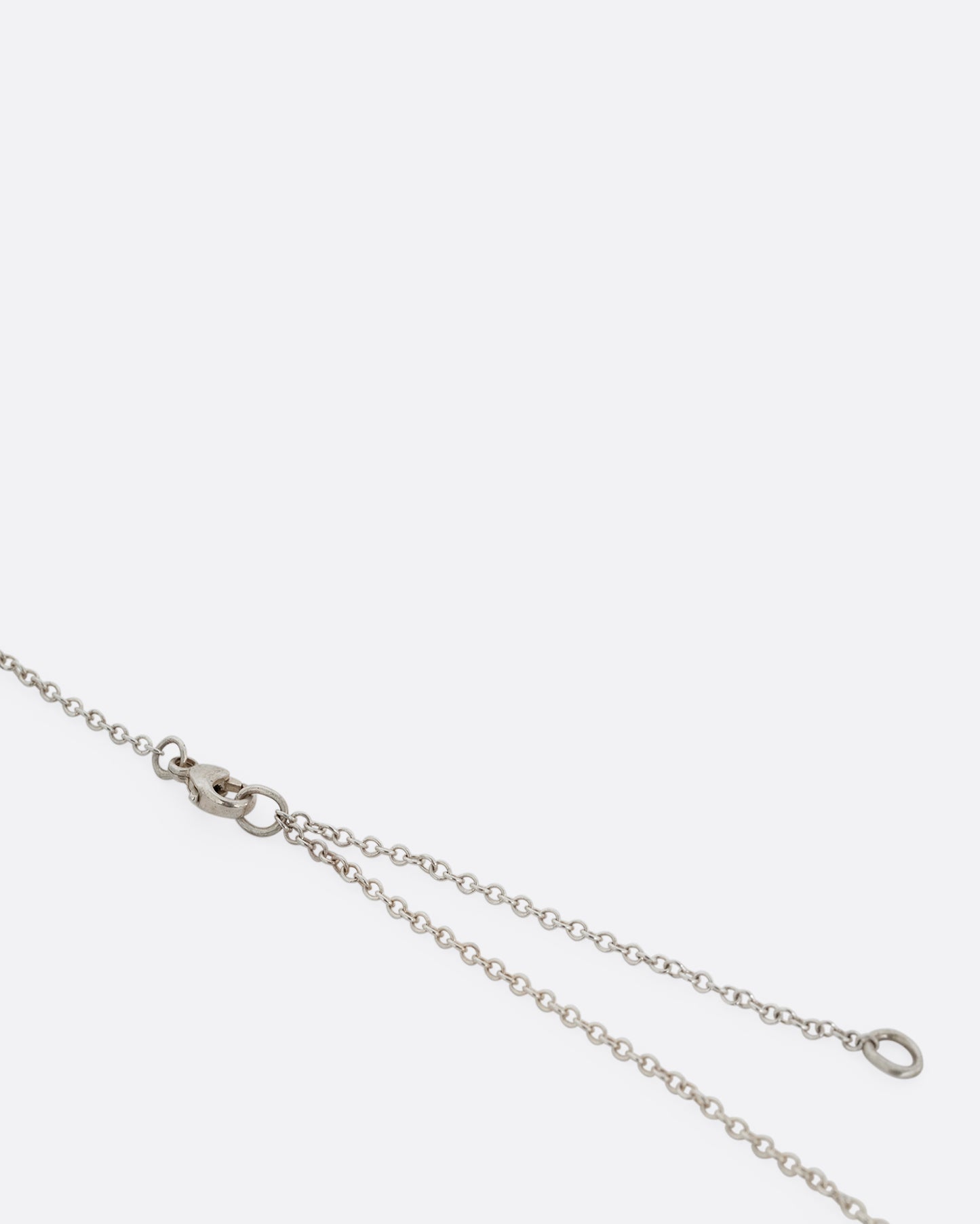 A close up of an adjustable silver cable chain and clasp. 