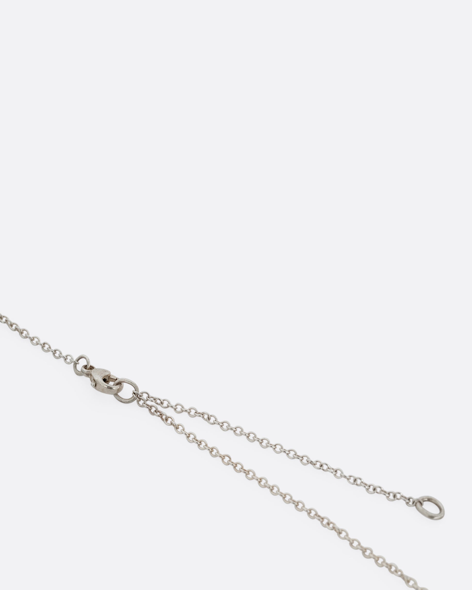 A close up of an adjustable silver cable chain and clasp. 