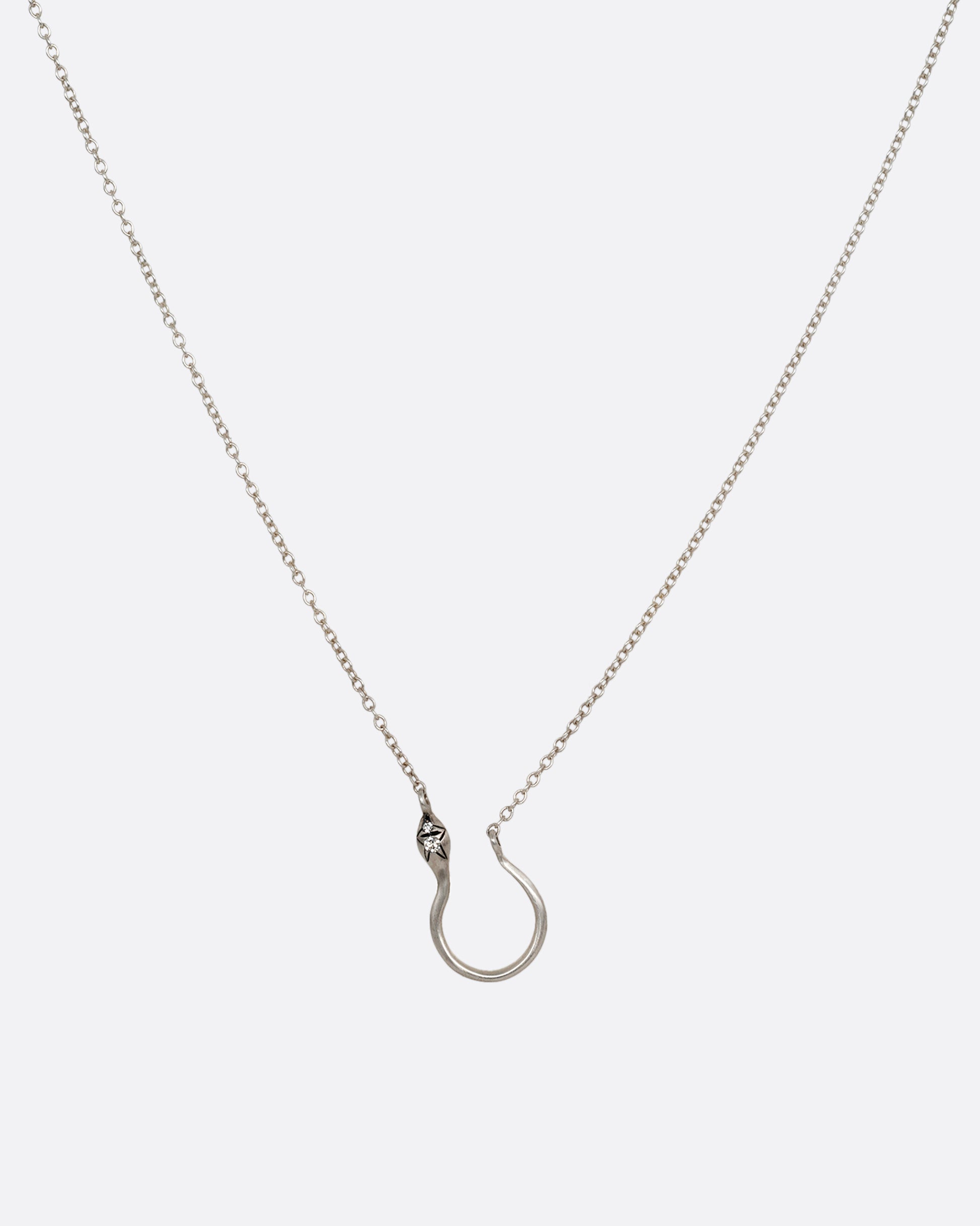 A silver snake shaped charm holder with diamonds on its face, hanging from a cable chain. Shown from the front.