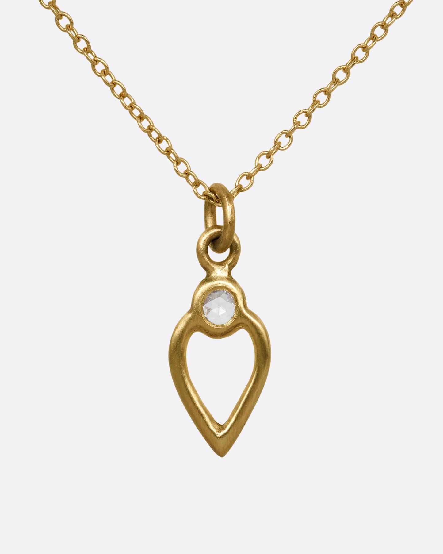 A yellow gold necklace with an open heart pendant with a diamond. Shown from the front.