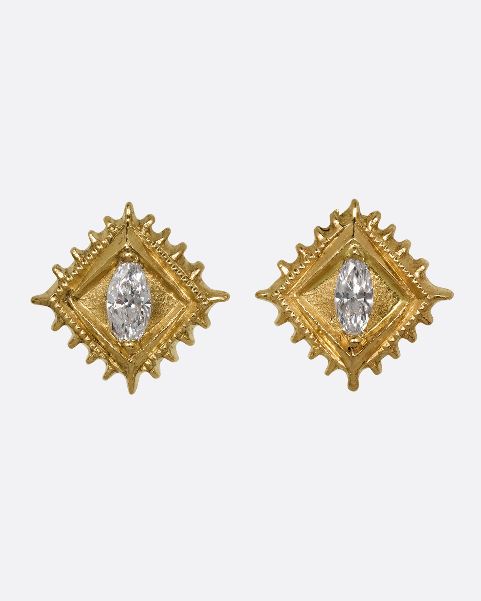 A pair of square yellow gold stud earrings with a milgrain border and white marquis diamond in the center. Shown from the front.