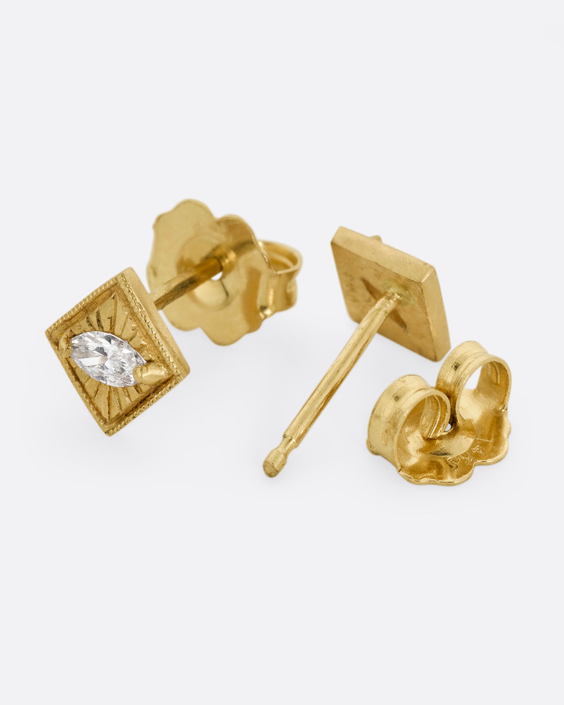 A pair of yellow gold square earrings with a milgrain border and marquis diamond in the center. One earring is shown from the front. The other earring is shown open from the back.