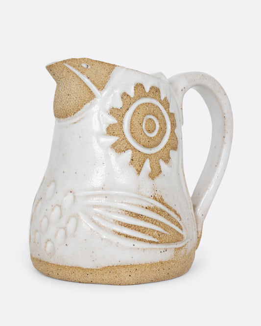 A white bird shaped creamer with a handle. Shown from the side.