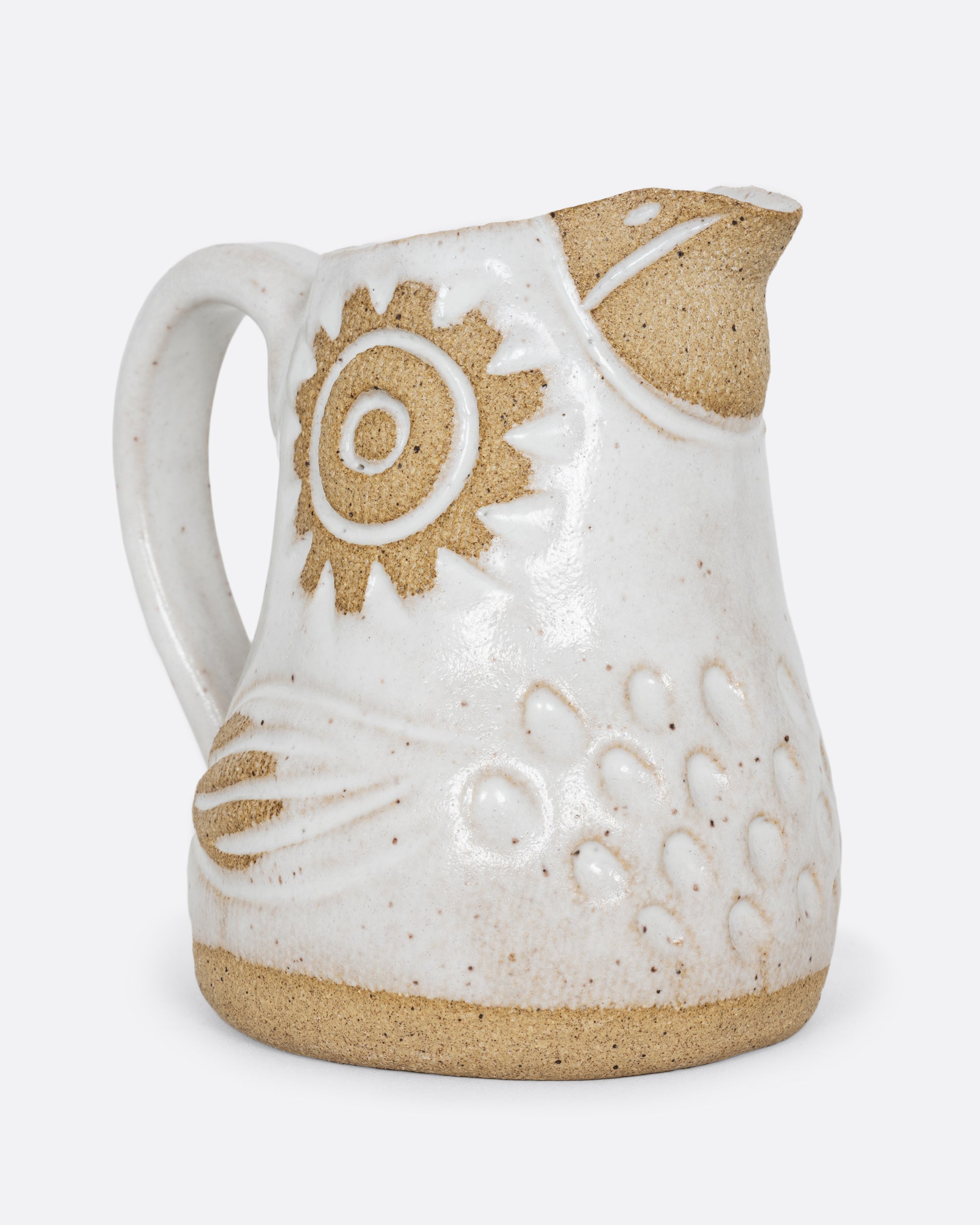 A white bird shaped creamer with a handle. Shown from the side.
