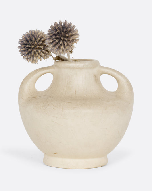 A cream colored vase with handles. Shown from the front with two globe thistle flowers in it.
