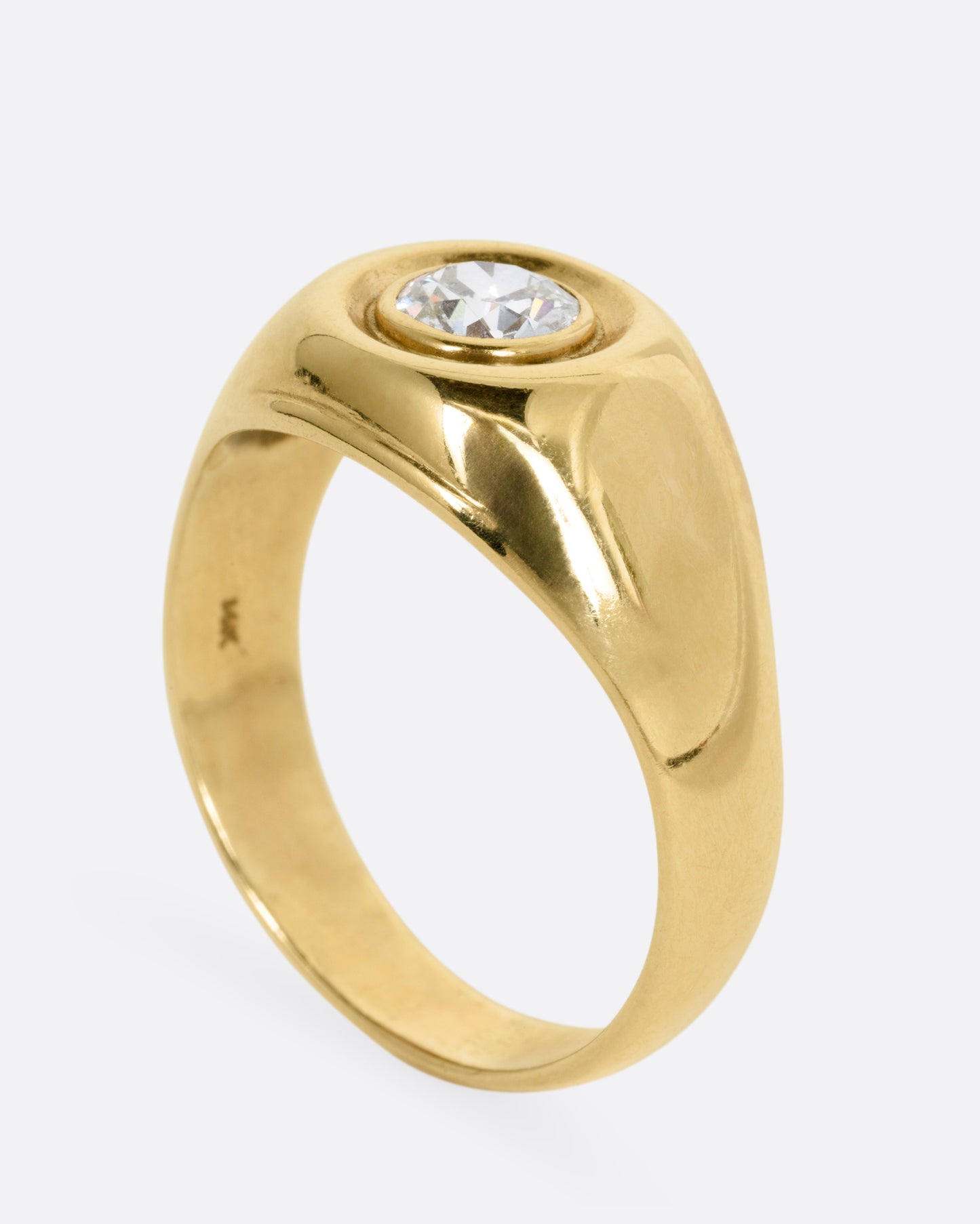 A yellow gold ring with a bezel set Old European Cut diamond. Shown standing up from the side.