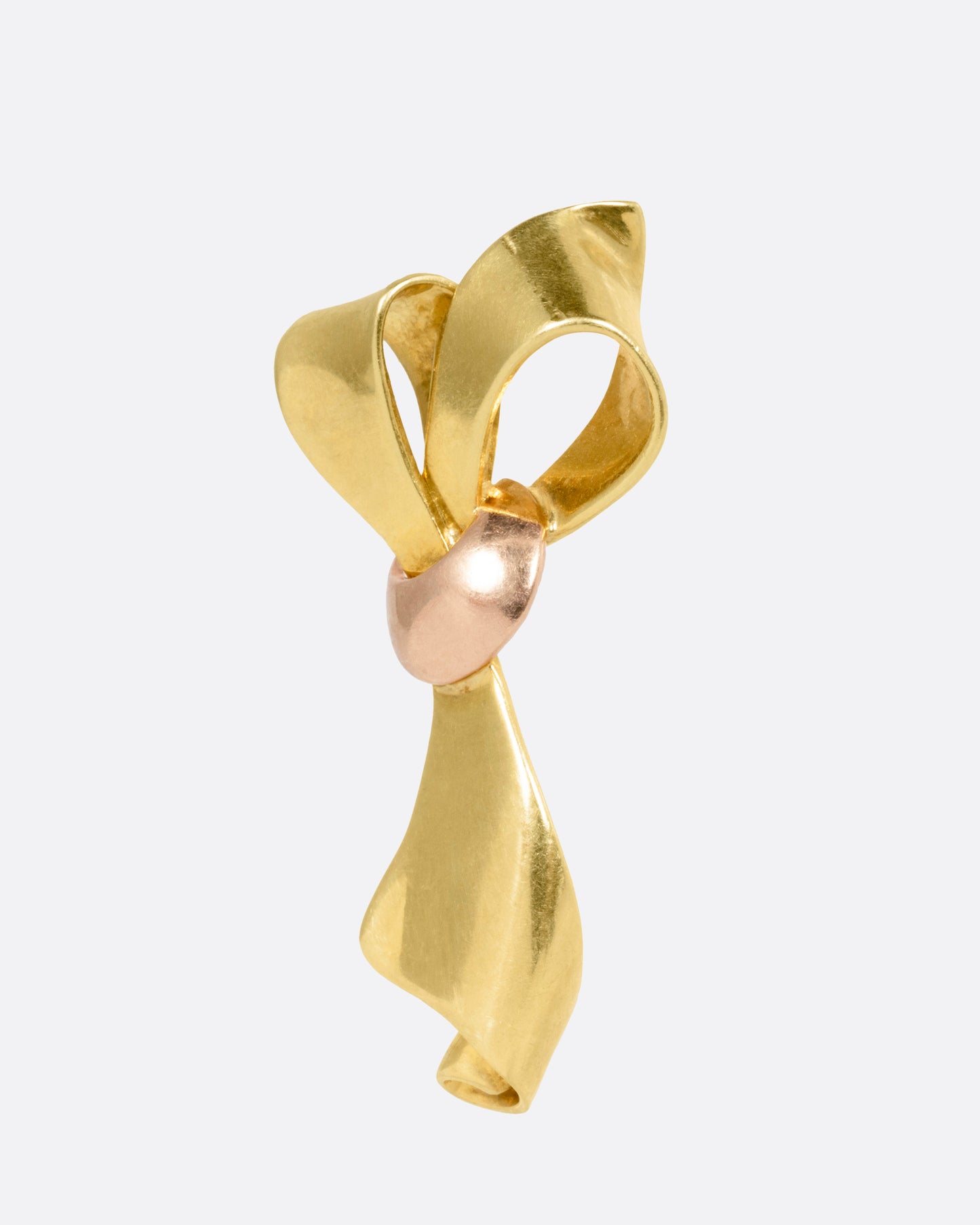 A yellow gold ribbon shaped earring with a rose gold knot, shown from the side.