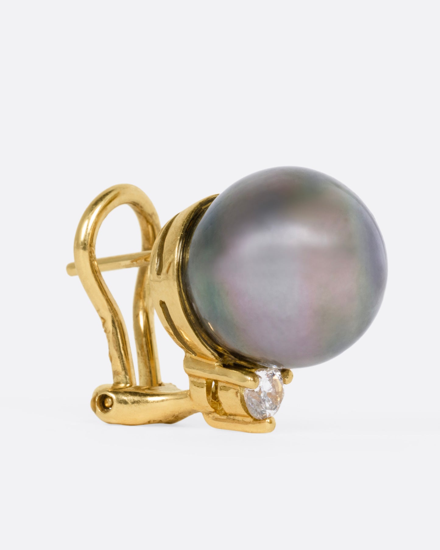A yellow gold earring with a black pearl, and a white diamond, shown from the side.