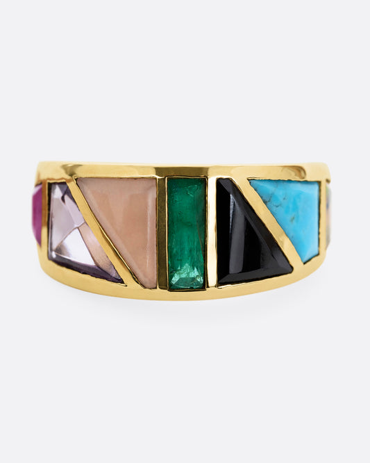 A yellow gold band with an array of gemstones in angular shapes. Shown from the front.