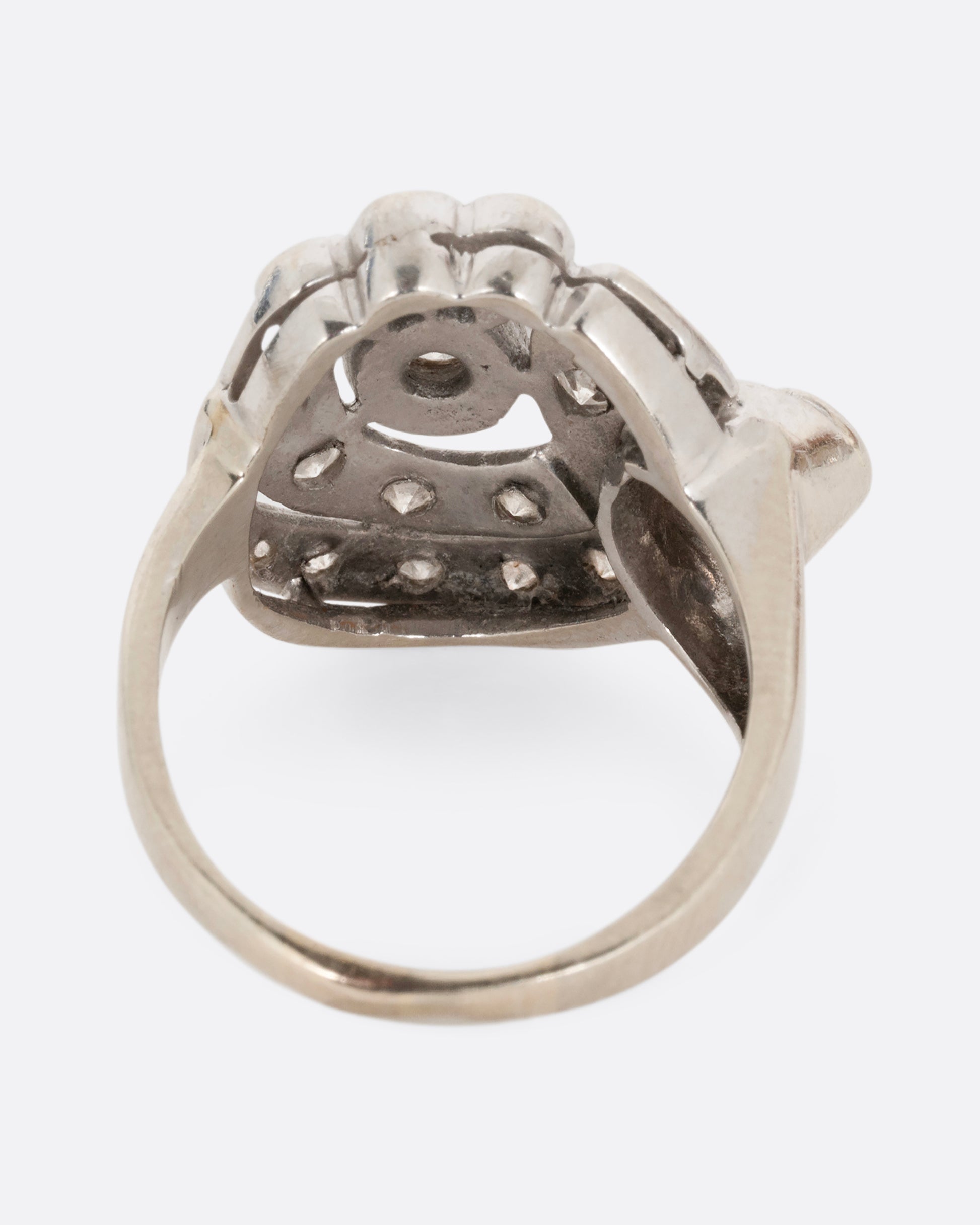 A white gold curving ring with diamonds. Shown from the back.