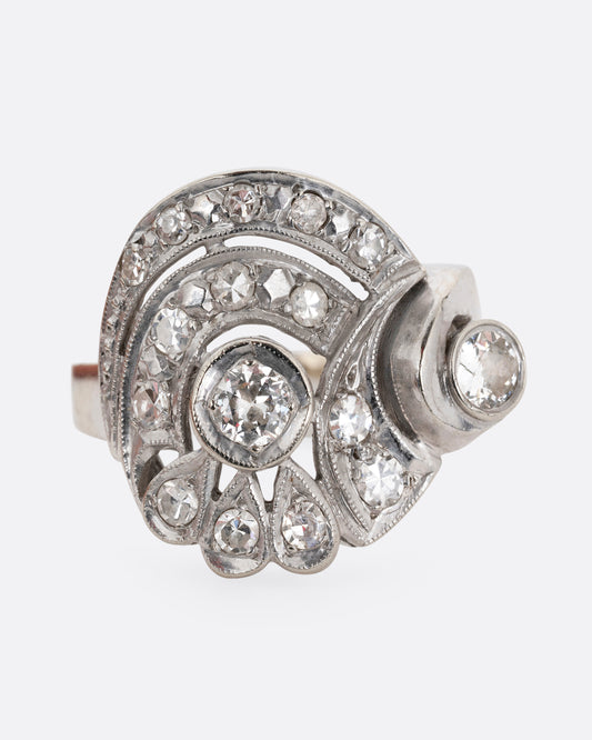 A white gold curving ring with diamonds. Shown from the front.