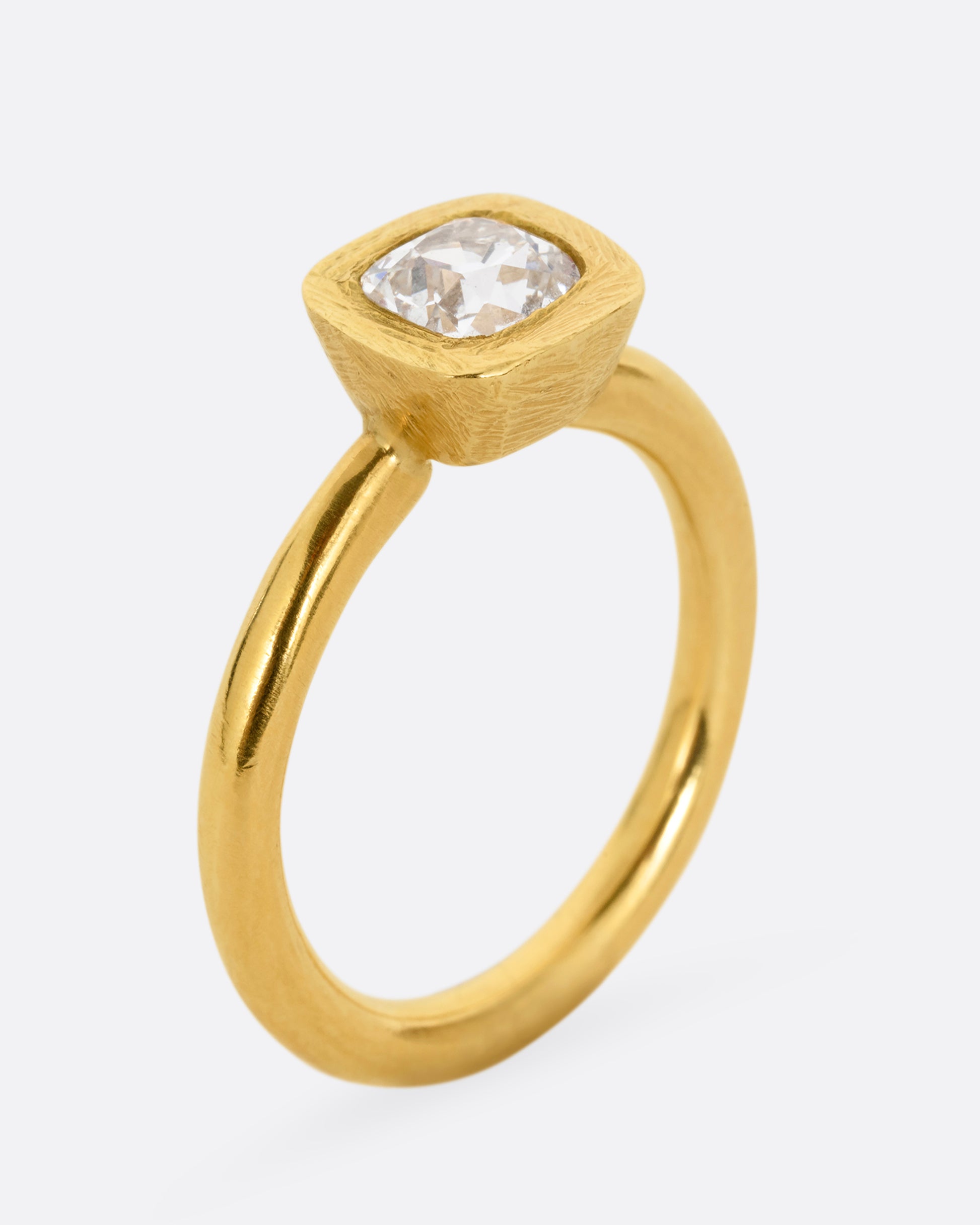 A yellow gold ring with an Old Mine Cut Diamond. Shown standing up from the side.