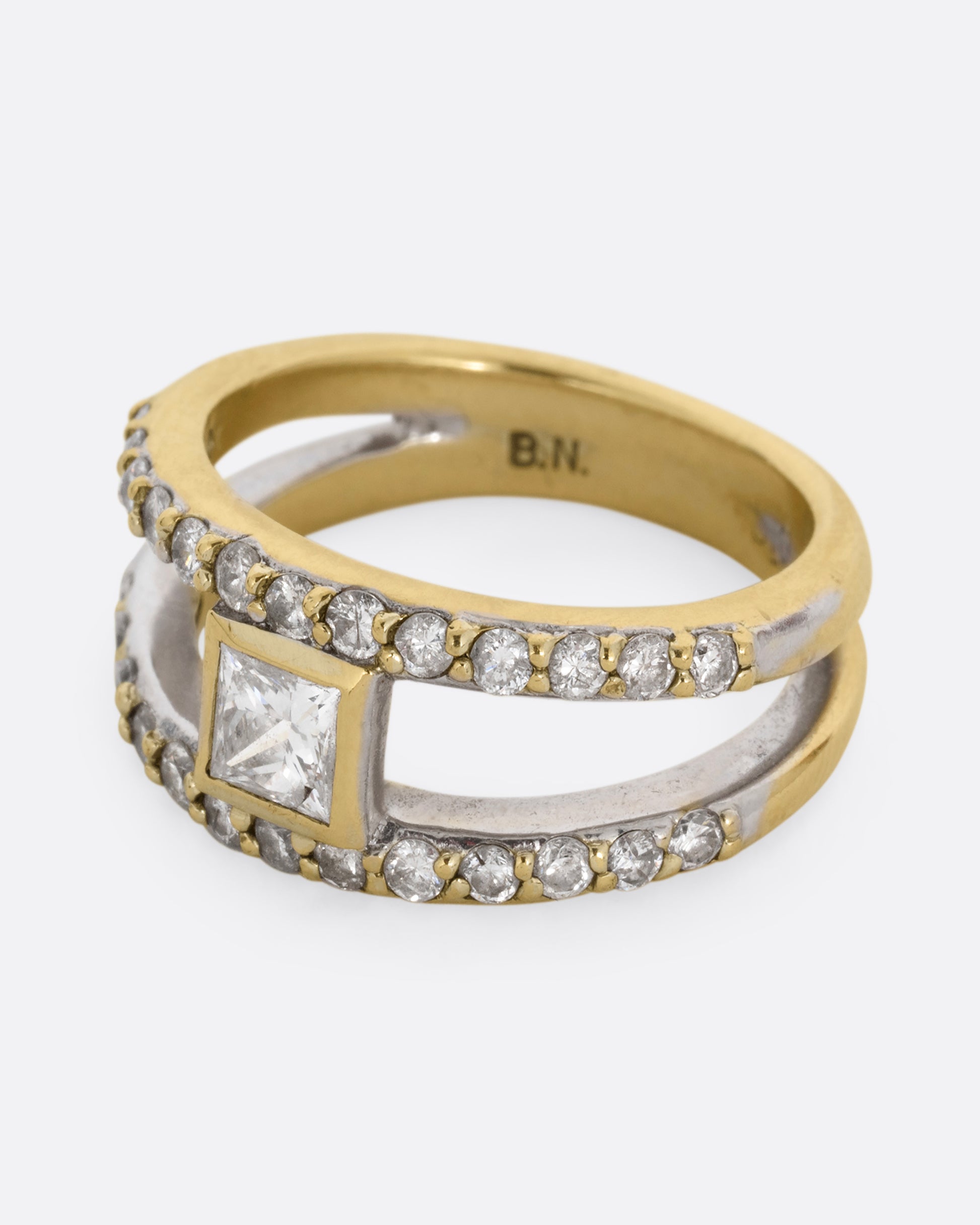 A yellow and white gold double band with pave diamonds and a center princess cut diamond. Shown from the side.