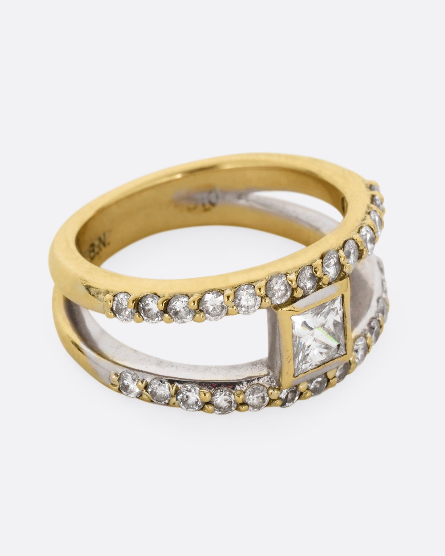A yellow and white gold double band with pave diamonds and a center princess cut diamond. Shown from the side.