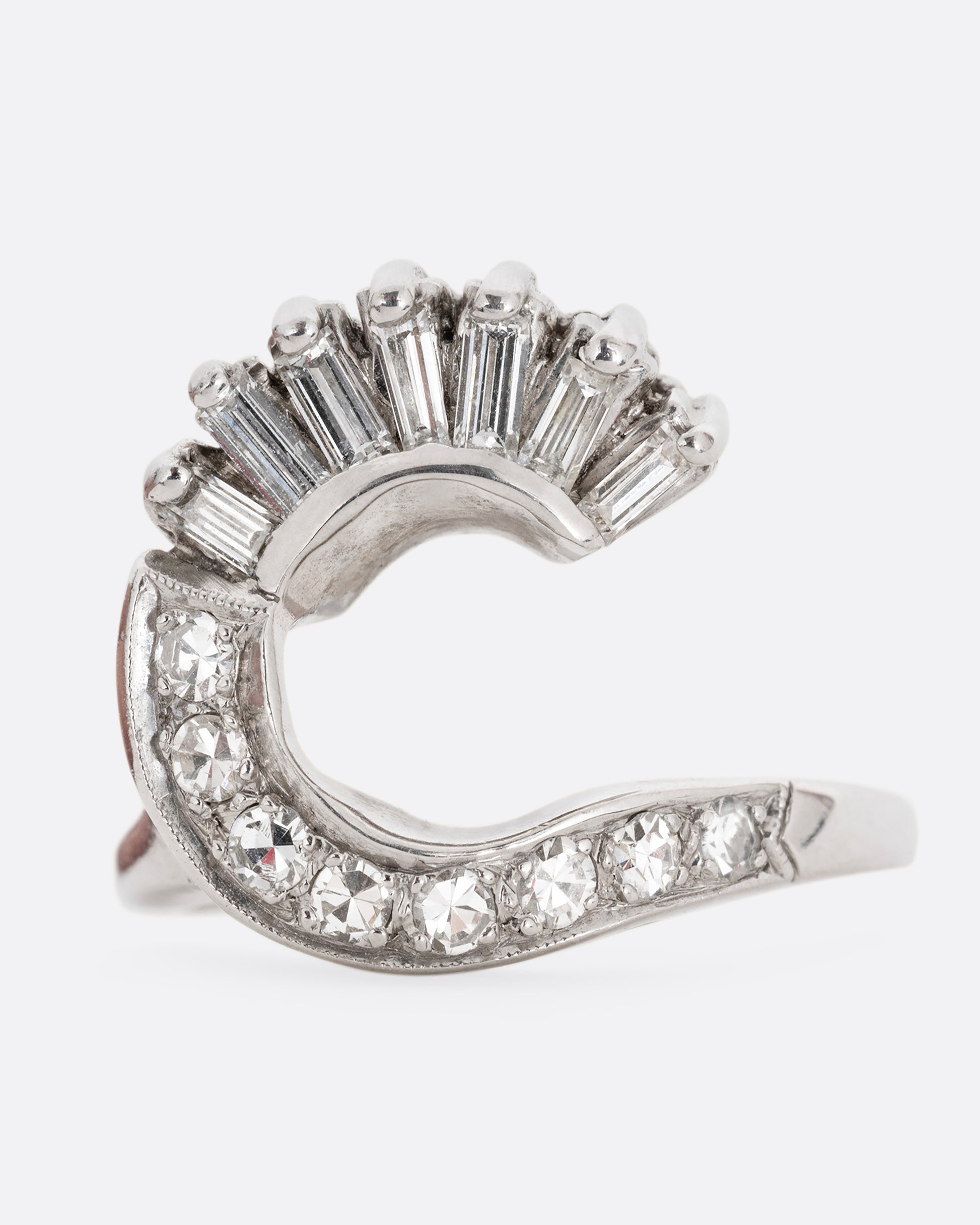 A white gold wave ring with baguette diamonds and round diamonds. Shown from the front.