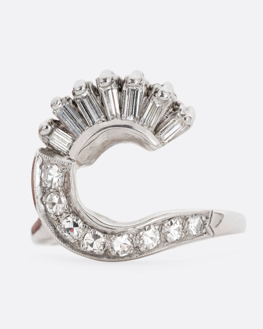 A white gold wave ring with baguette diamonds and round diamonds. Shown from the front.