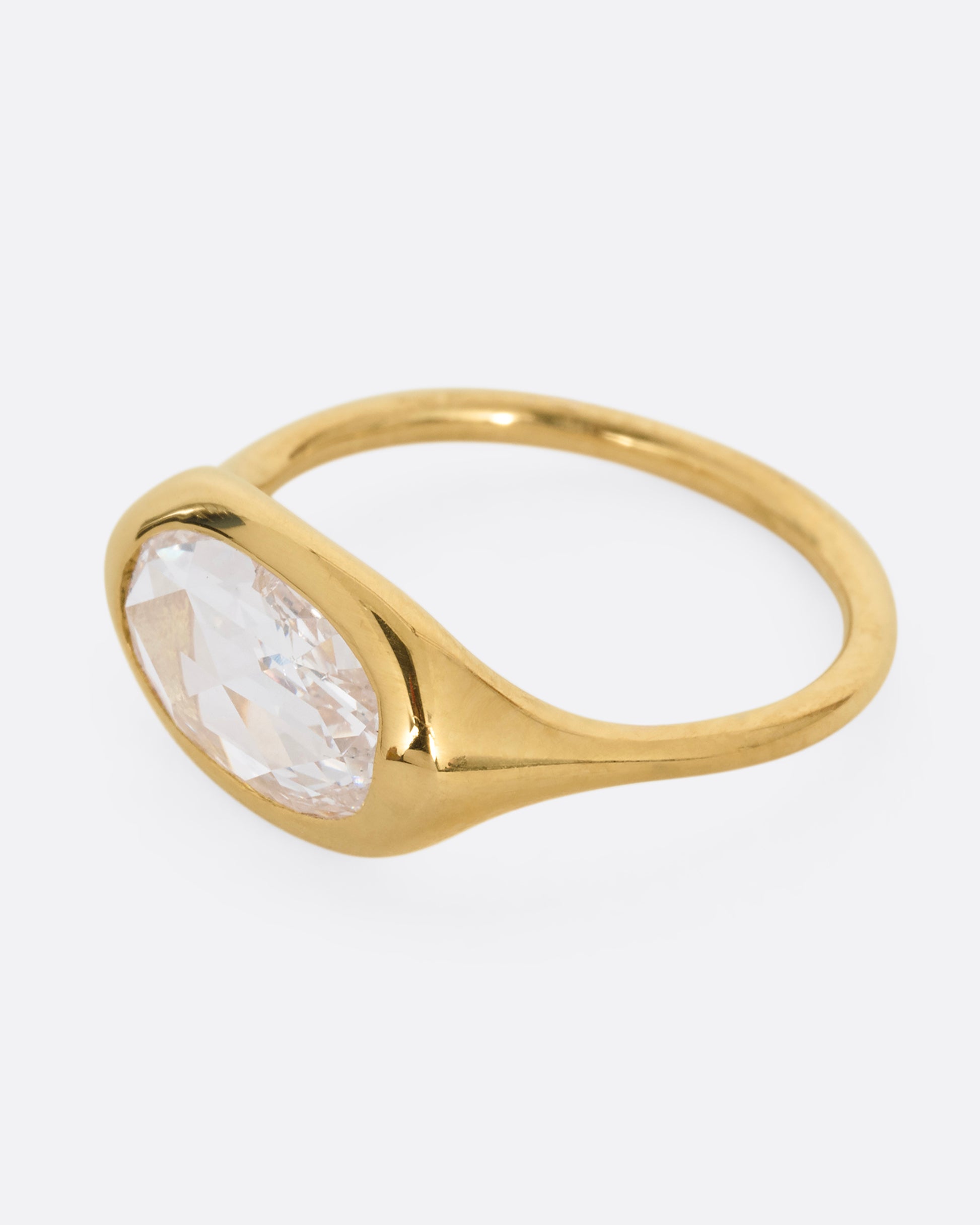 A yellow gold ring with a n oval rose cut diamond. Shown from the side.