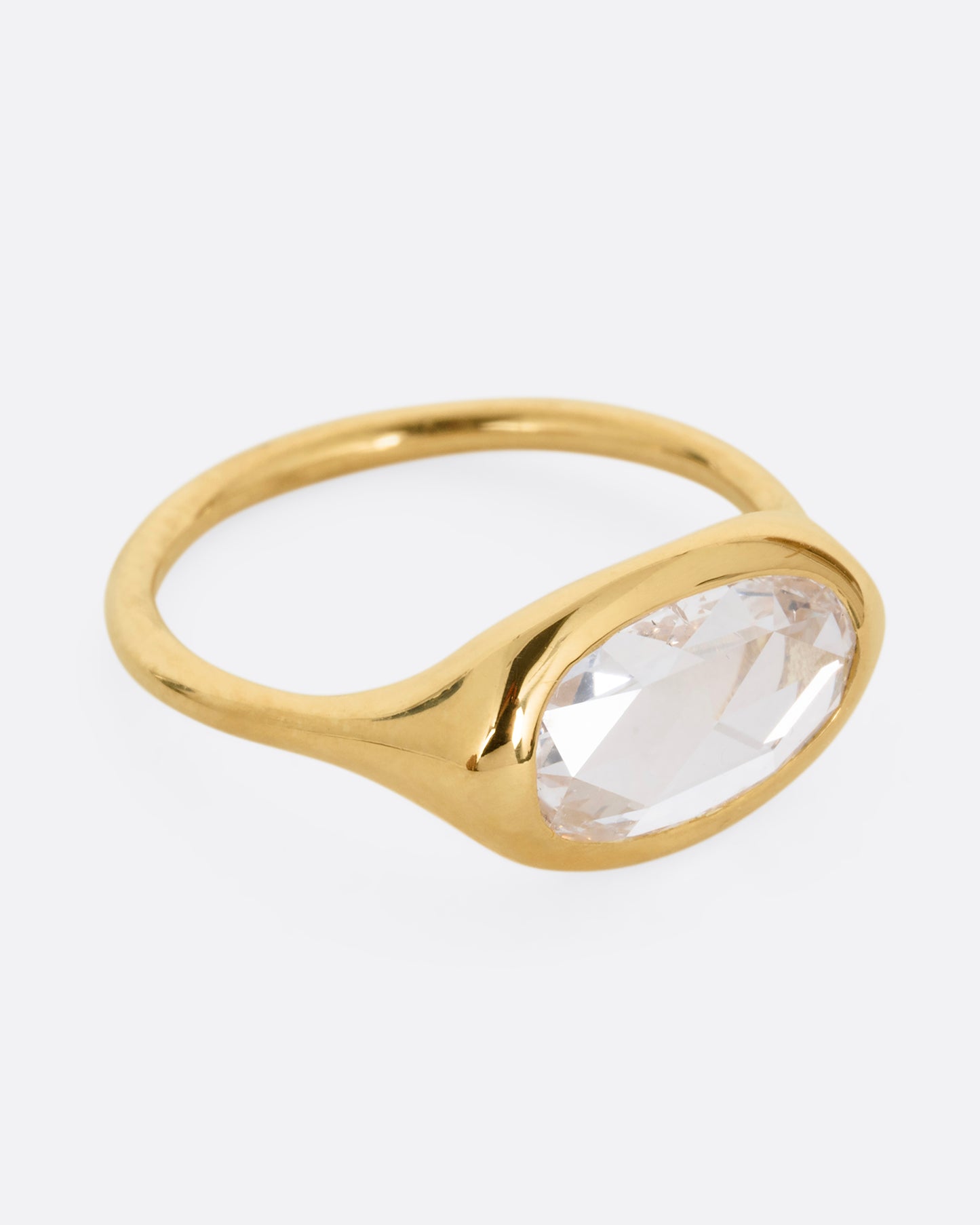 A yellow gold ring with a n oval rose cut diamond. Shown from the side.