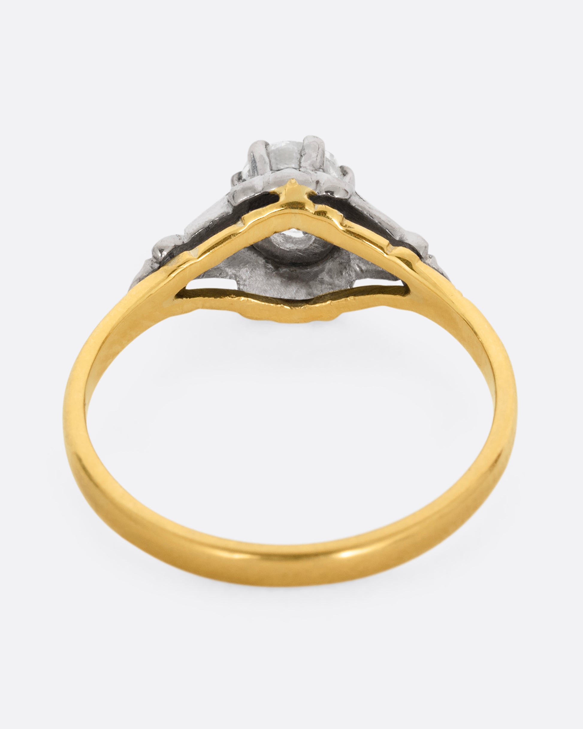 A yellow gold and platinum ring with an Old Mine Cut diamond and baguette diamonds. Shown from the back.