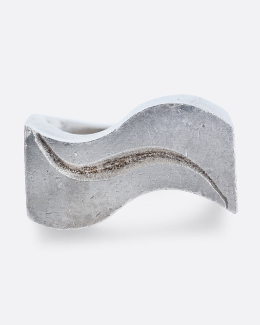 A silver ring with two waves on its face. Shown from the front.