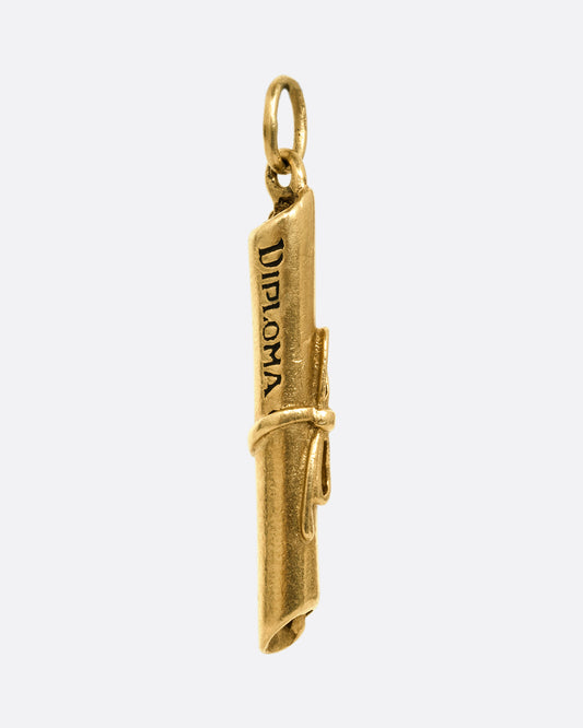 A yellow gold scroll tied with ribbon with 'Diploma' engraved on its side. Shown from the front.