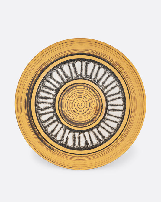 A round serving plate with a sun motif in yellow, brown, and white. Shown from the top.
