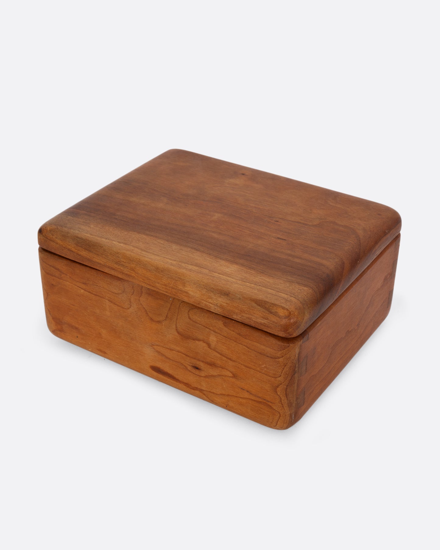 A wooden box with a hinged top and sliding ring holder. Shown closed from the top.