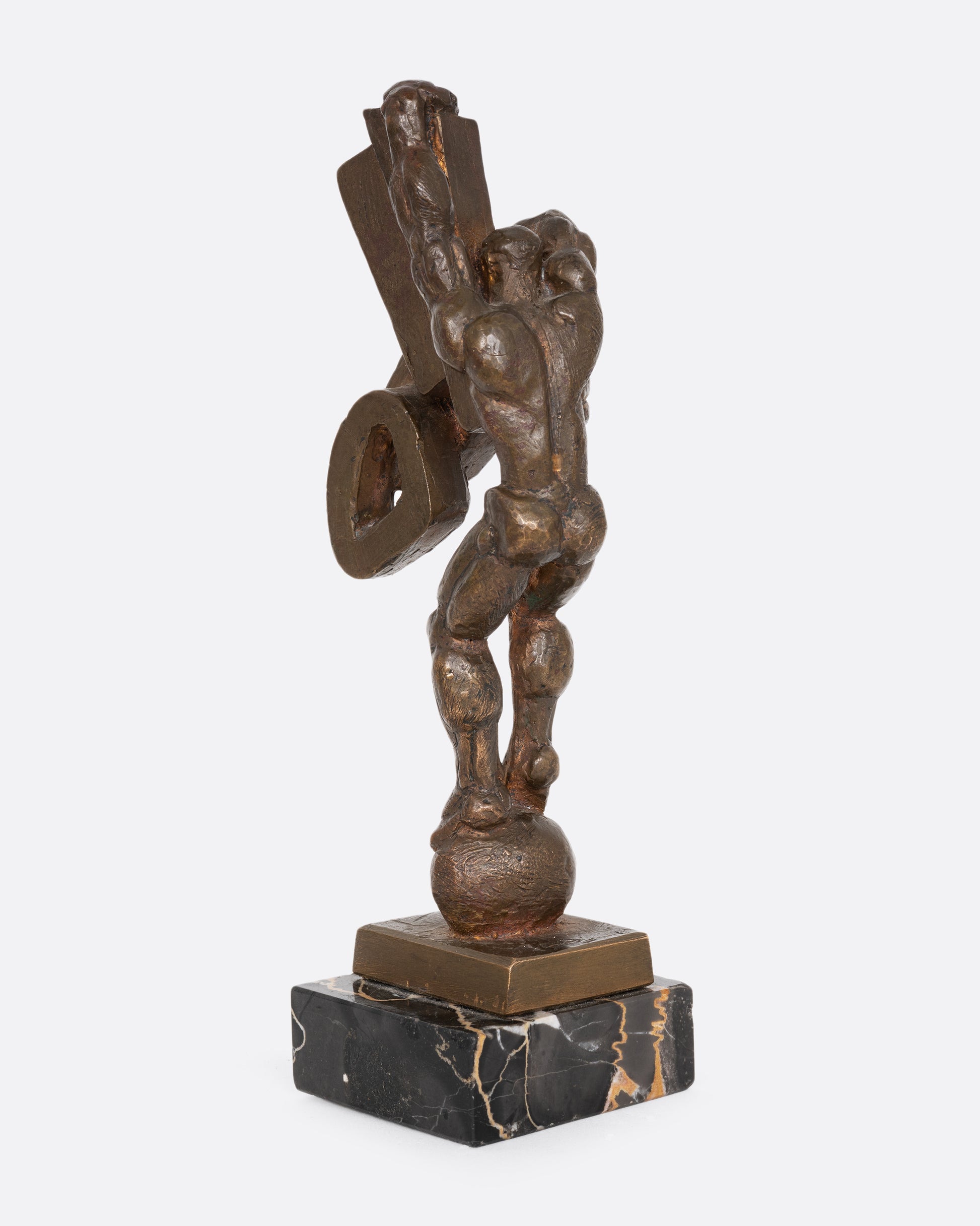 A Brutalist sculpture with geometric shapes and a human figure. Shown from the back.