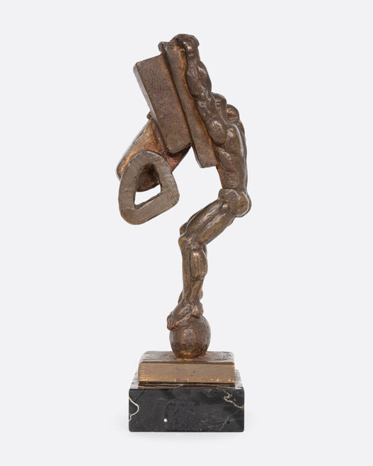 A Brutalist sculpture with geometric shapes and a human figure. Shown from the side.