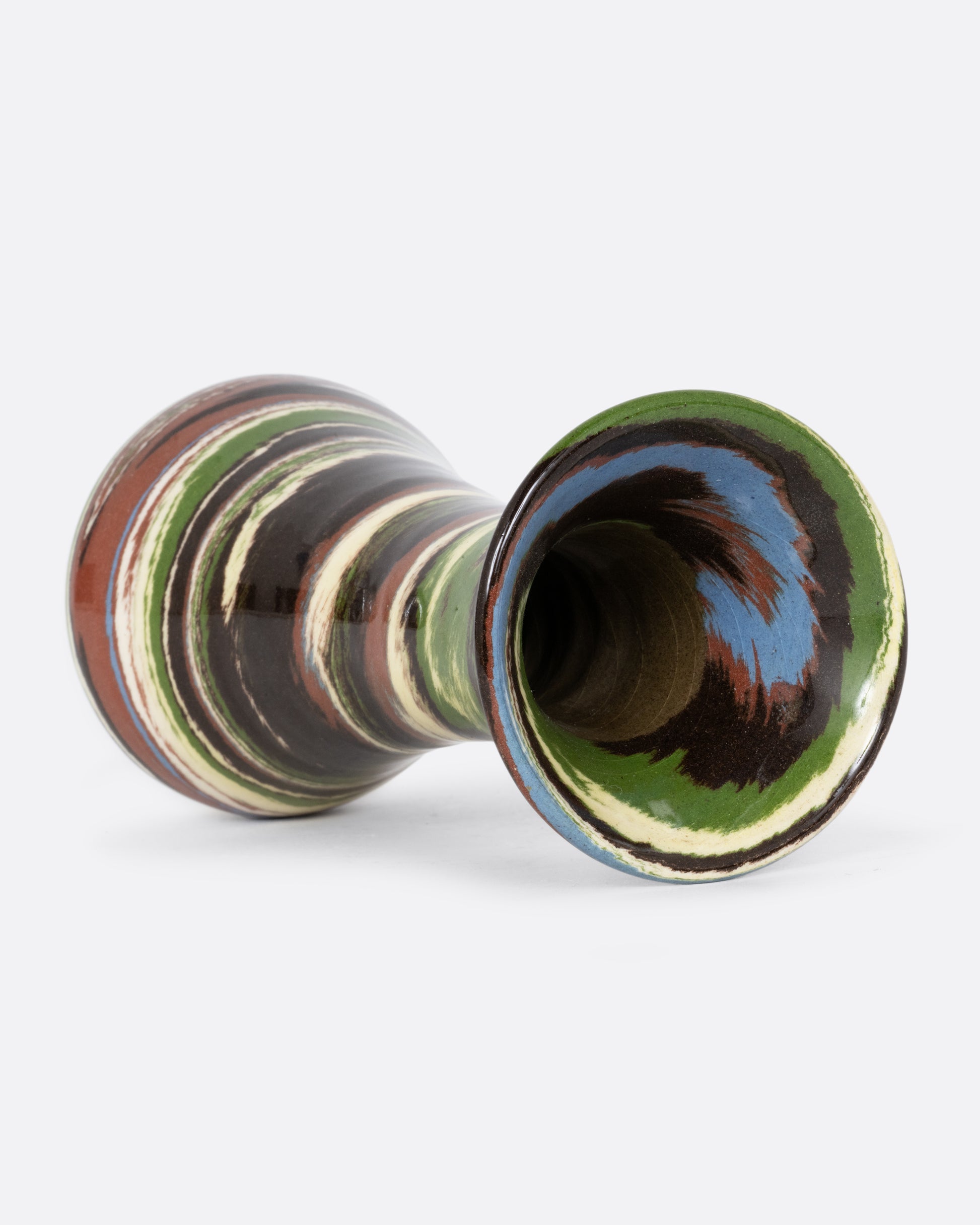 A green, brown, and white swirled bud vase. Shown lying flat from the top.